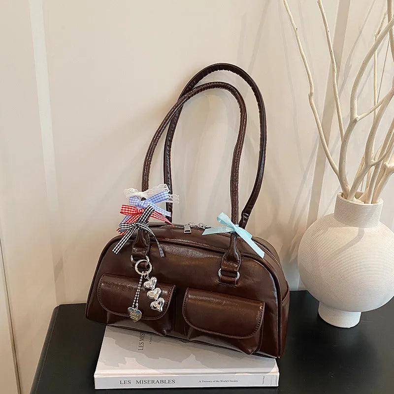 Retro style women's PU leather pillow-shaped flap handbag in black, shown with a double shoulder strap.