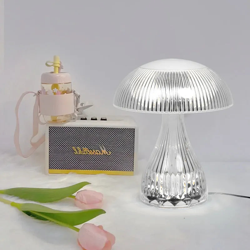 Small white rechargeable touch night lamp with three-colour changing light on wooden table