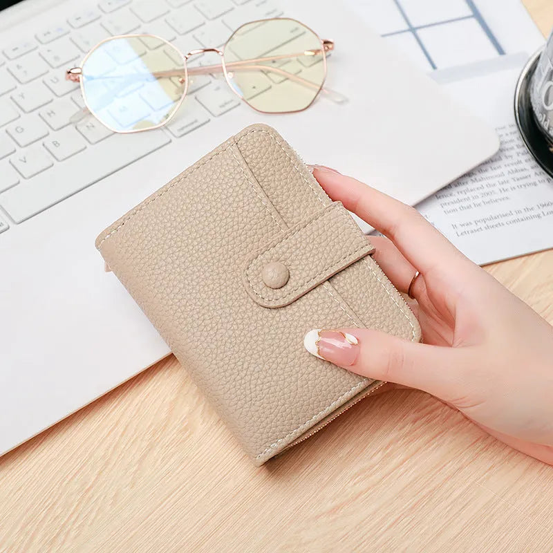 Women's solid colour short wallet with lychee pattern and sewing thread detail in multiple colours.