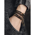Black multi-layered beaded bracelet with geometric shapes and colourful retro patterns