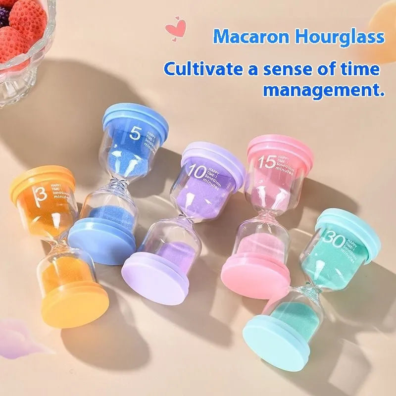 Handmade glass sand timer in blue on a wooden desk, showing sand flowing through the centre.