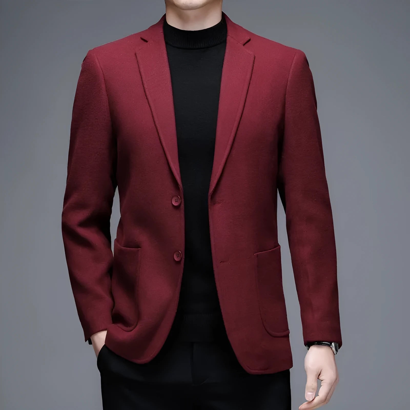 Man wearing a solid grey loose-fit woolen suit jacket with long sleeves.
