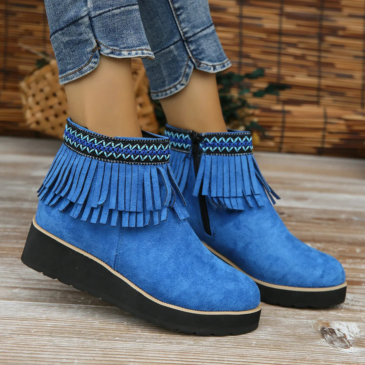 Women's suede ankle boot with wedge heel, side zipper, tassel detail, and thick rubber sole in three colour options.