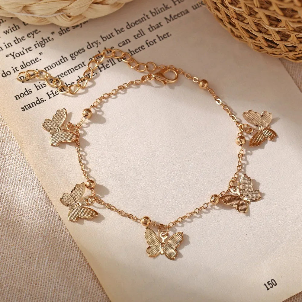 Alloy hollow butterfly design anklet in gold finish on a woman's ankle, beach foot ornament style