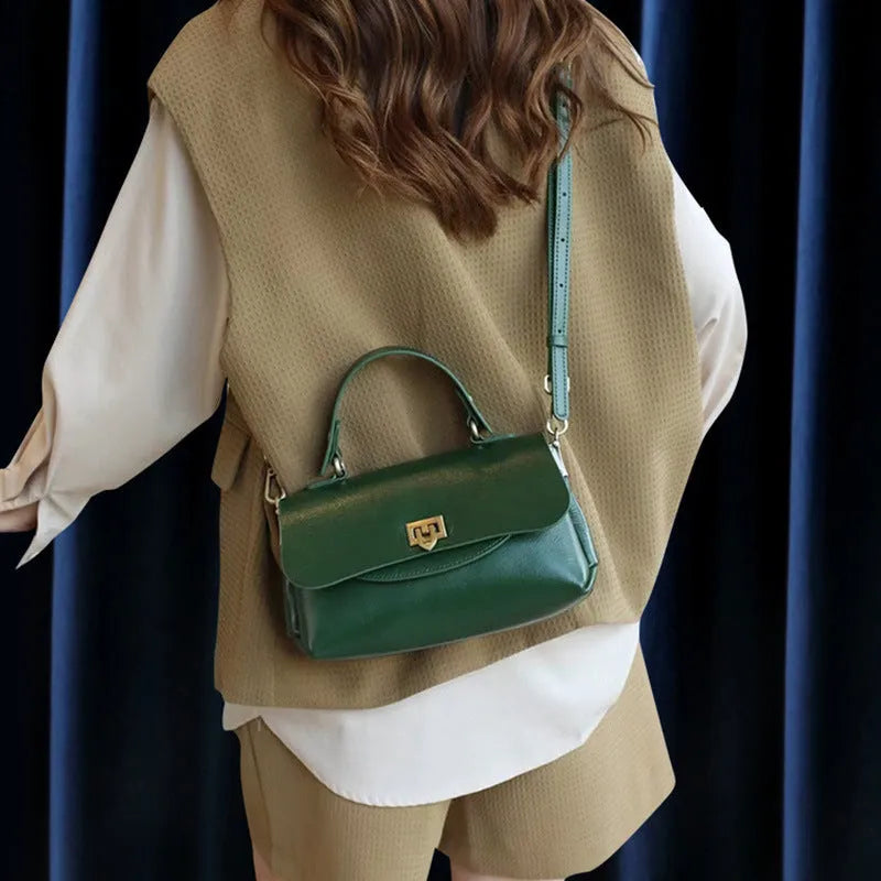 Women's brown leather saddleback handbag with double straps and multiple compartments