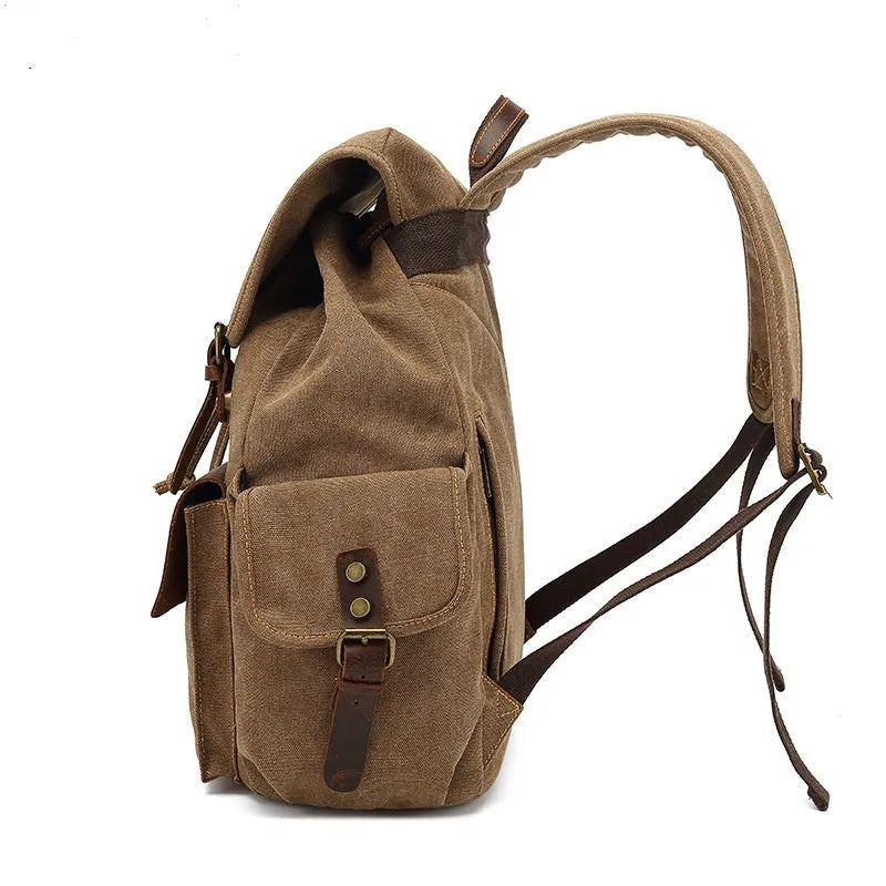 Retro military green canvas backpack with antique bronze hardware on a plain background.