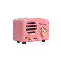 Vintage wood effect Bluetooth speaker in pink, black and wood grain colours showing compact size
