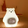 White silicone cartoon bear night light with remote control on a surface.