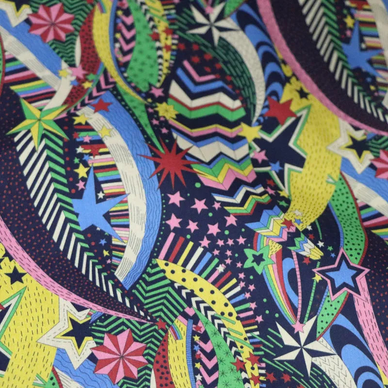 Blue floral printed cotton fabric on a roll showing plant and flower design, 145cm wide.