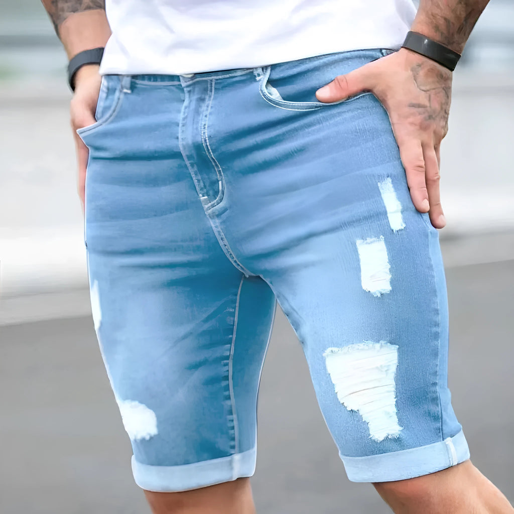 Men's sky blue denim shorts with distressed multi-hole design and straight leg cut