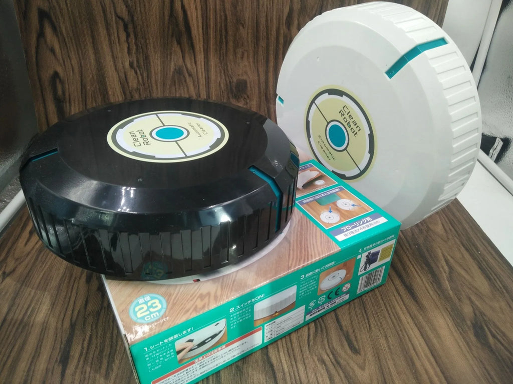 Black or white AC automatic sweeping robot on a hardwood floor next to a dust bin.