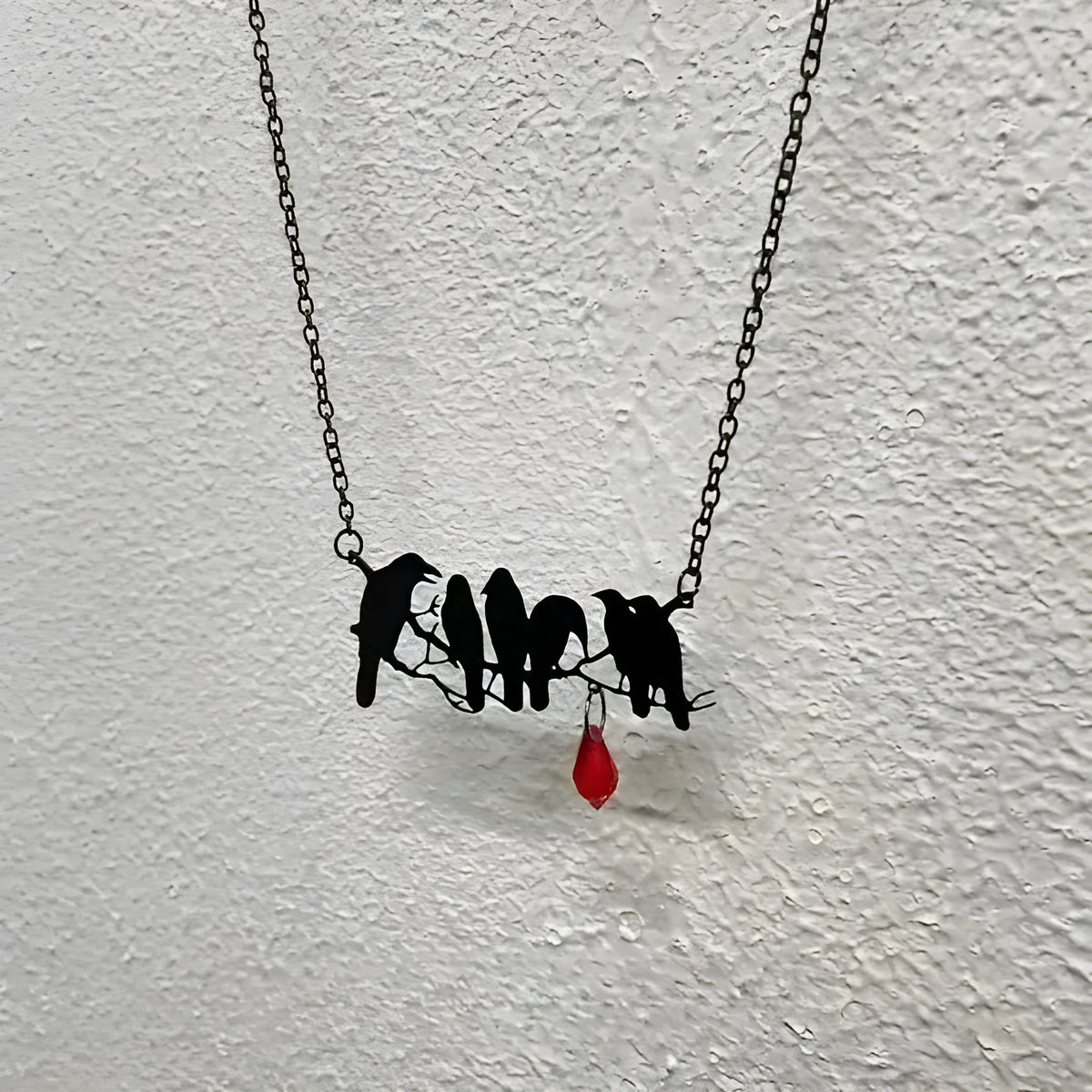 Black alloy crow pendant necklace with electroplated finish and cross chain, gothic bird jewellery.