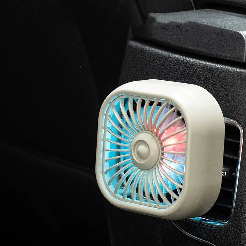 Small black USB electric fan with three speed buttons next to a charging cable