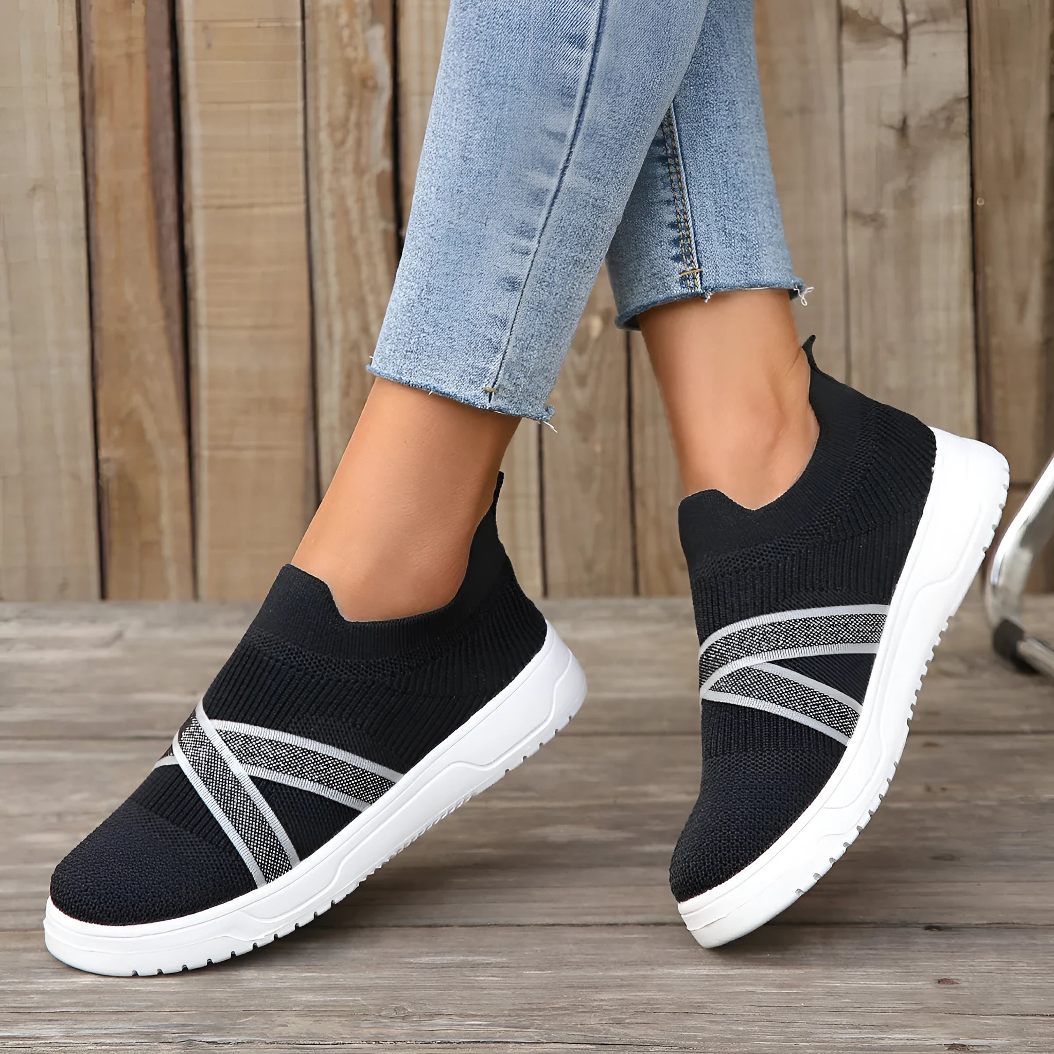 Black women's flat shoes with flyknit mesh upper, round toe, and tassel detail