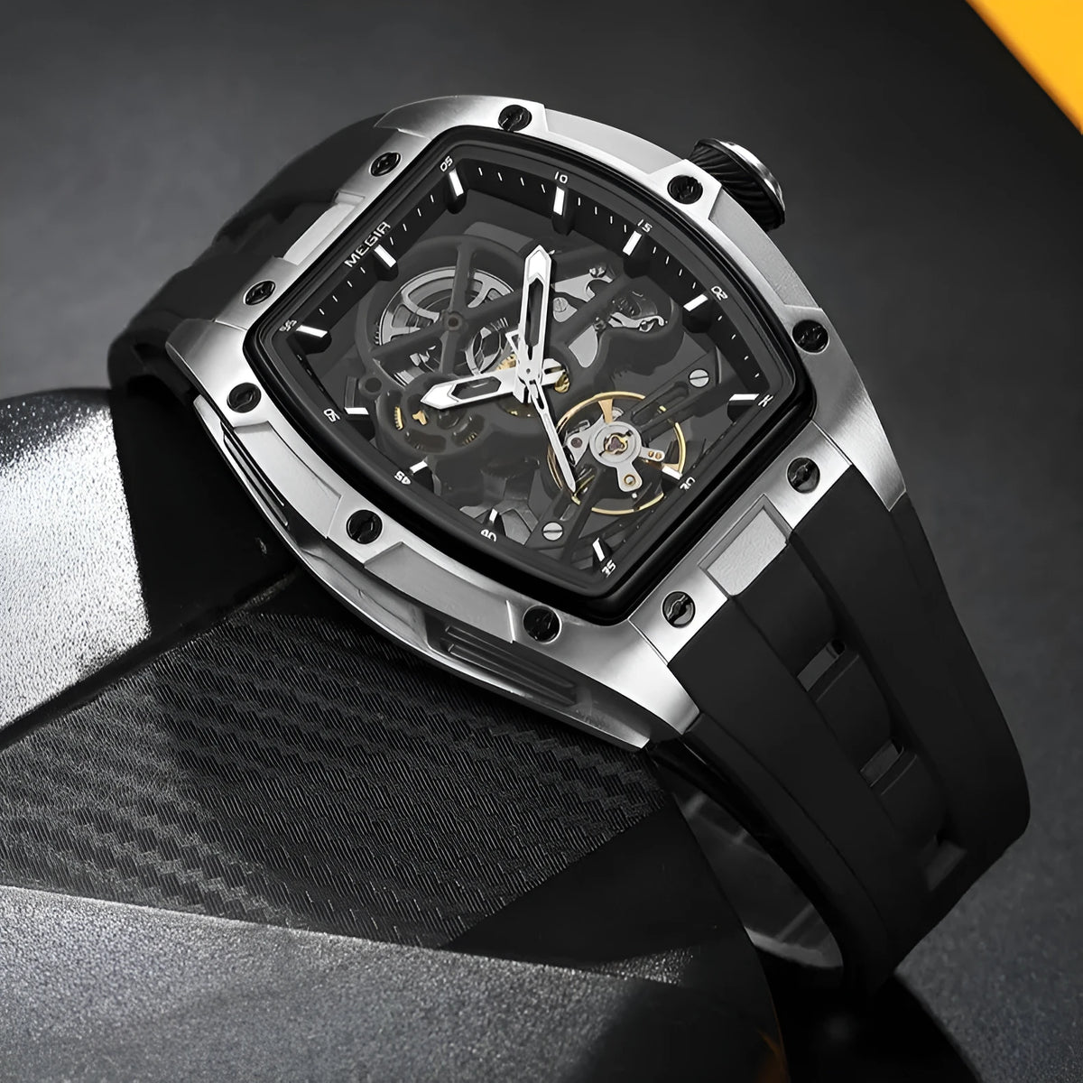 Men's mechanical skeleton watch with hollow dial, steel case, and black silicone band on wrist