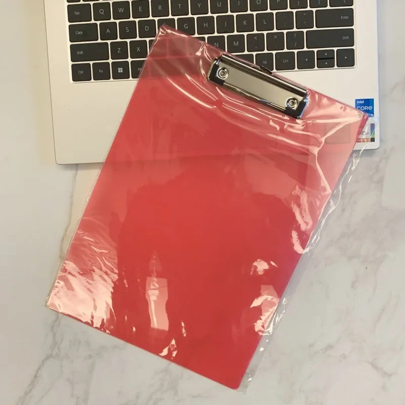 A4 transparent plate holder writing board with metal clip, shown in blue on a desk.