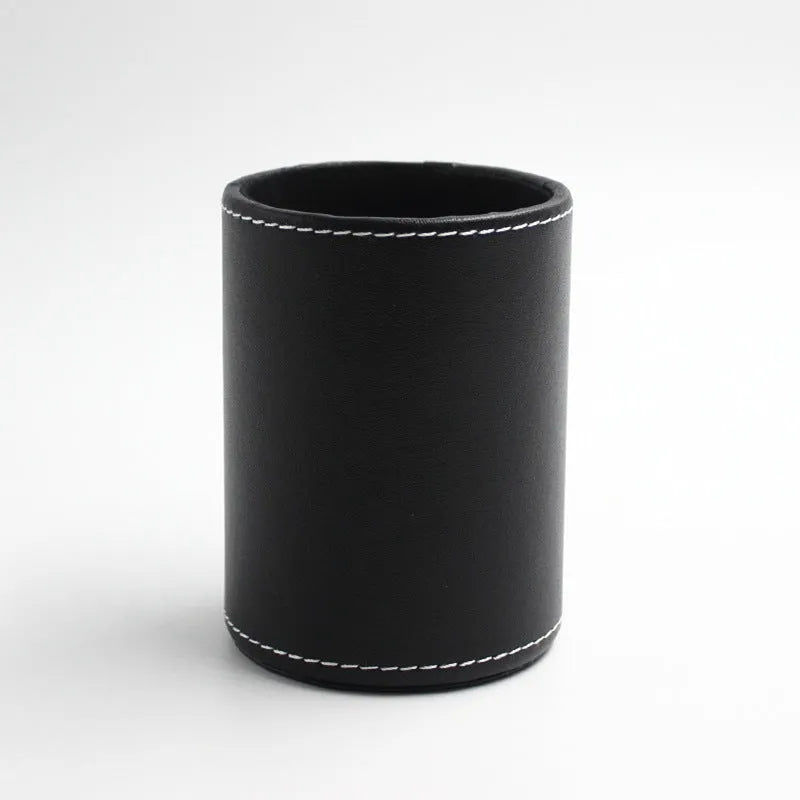 Small round black leather pen container on a desk