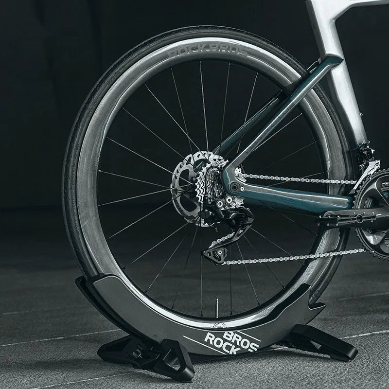 Black ABS plastic wall-mounted bicycle parking rack holder holding a mountain bike.