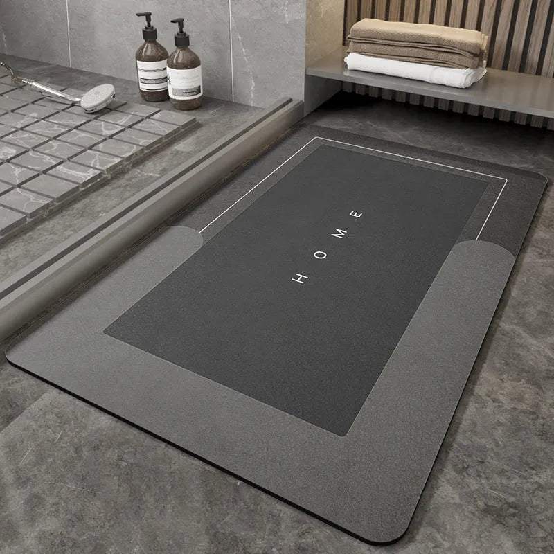 Blended fibre machine woven bathroom floor mat in blue, shown in an oval shape on a tiled floor.