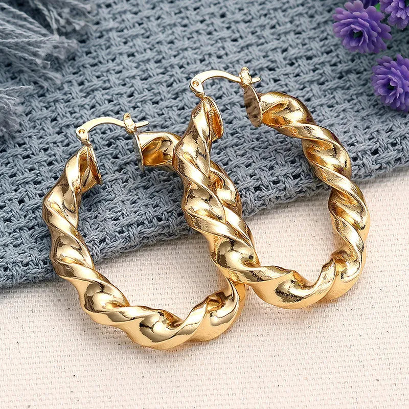 A pair of women's geometric drop-shaped clip-on earrings with a ring design in an electroplated copper finish.