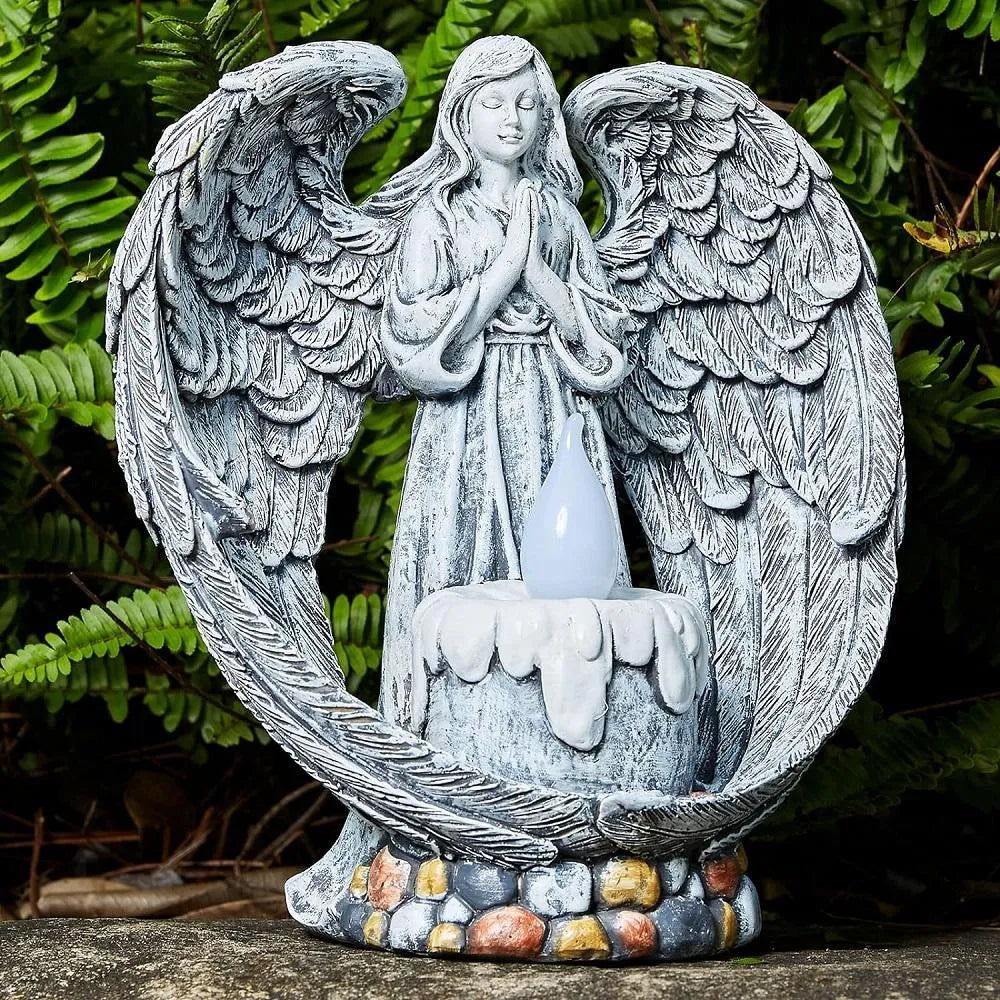 Grey resin praying angel solar garden statue on grass with wings and hands clasped