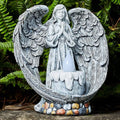 Grey resin praying angel solar garden statue on grass with wings and hands clasped