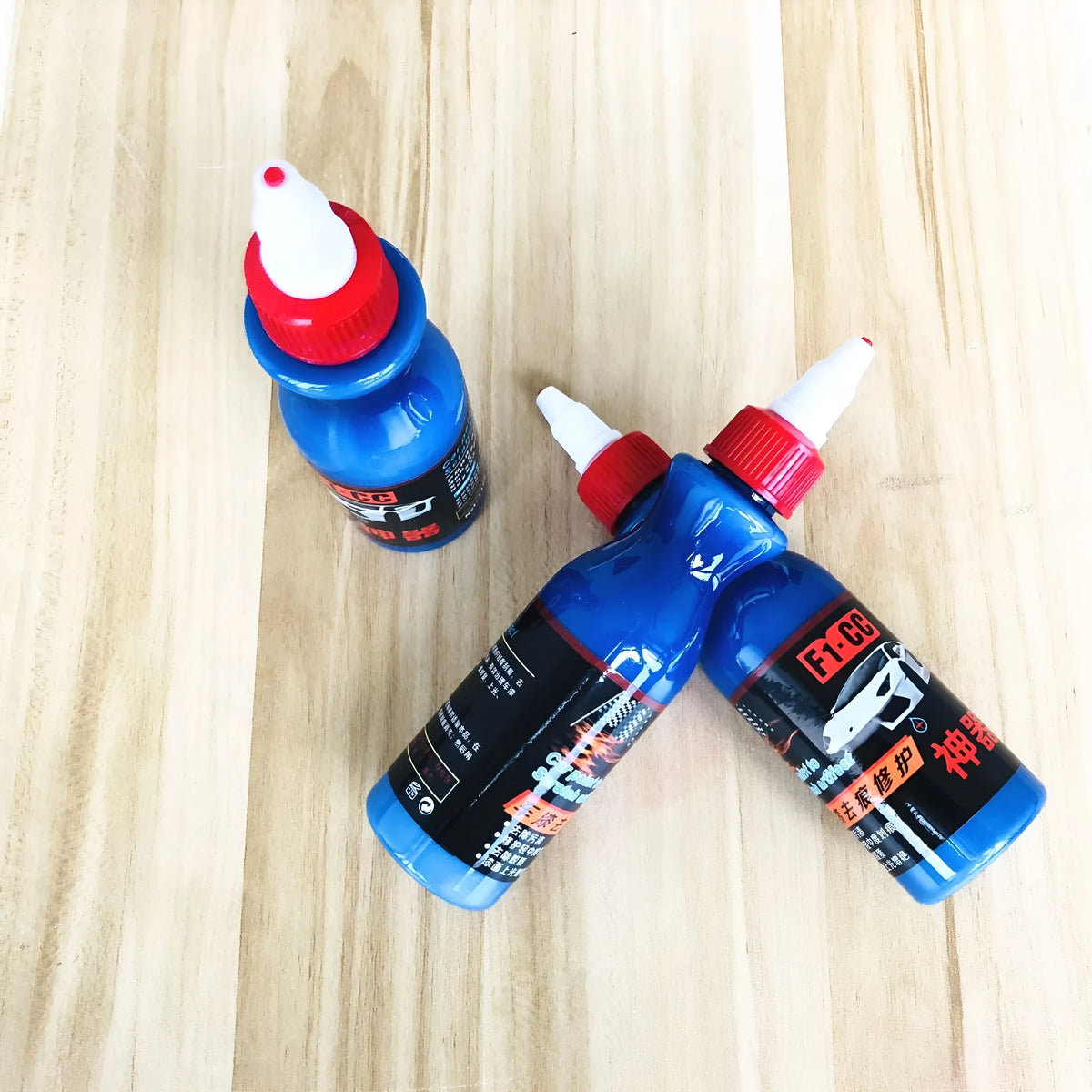 Small blue car wiping tool with scratch repair agent bottle for automotive paintwork touch-up applications