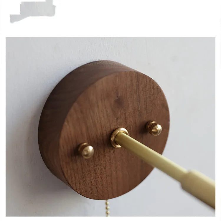 Inn Niche Nordic wooden wall-mounted bedside lamp in walnut colour on a light wall.
