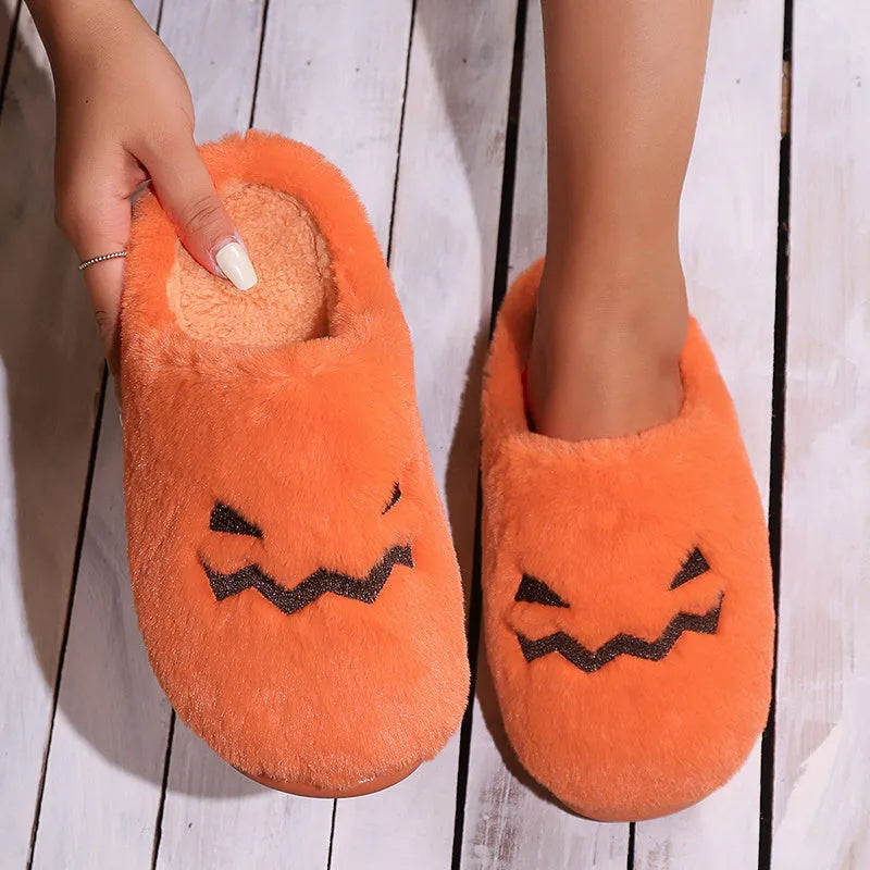 Orange Halloween pumpkin slippers with coral velvet upper and plush lining on a non-slip PVC sole.