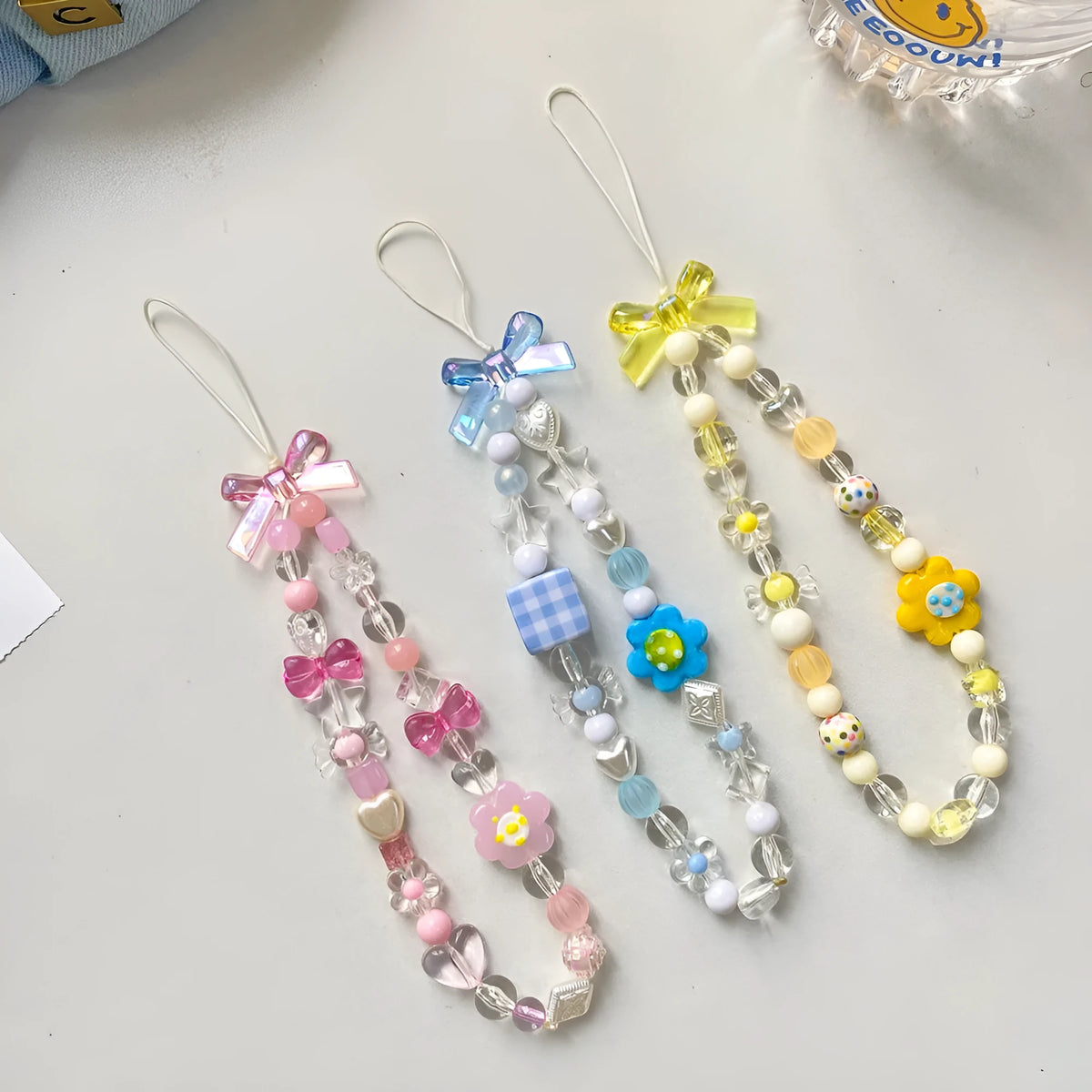 Beaded flower phone lanyard with floral charm on adjustable rope strap in blue, pink, or yellow