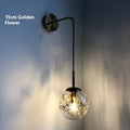 Modern glass wall-mounted bedside lamp in gold or silver finish, shown in 15cm and 20cm size options.