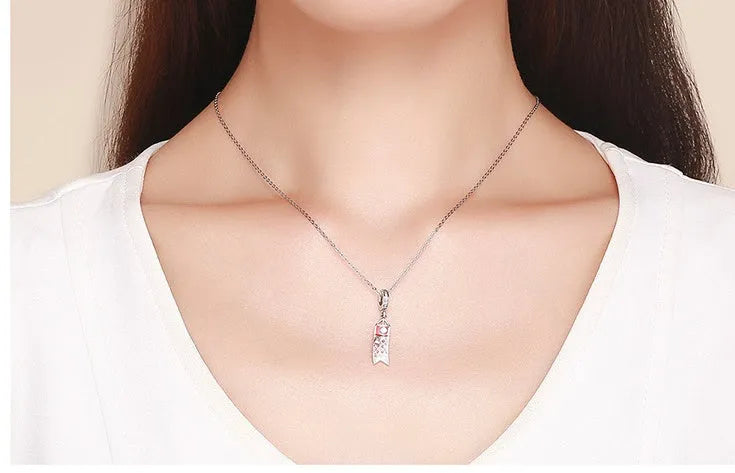 S925 sterling silver carp streamer pendant with zircon detailing on a dark background