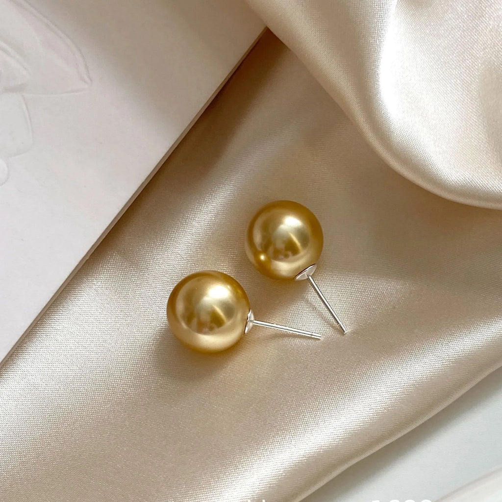 Large pearl stud earrings with geometric silver settings and eight-pointed star details
