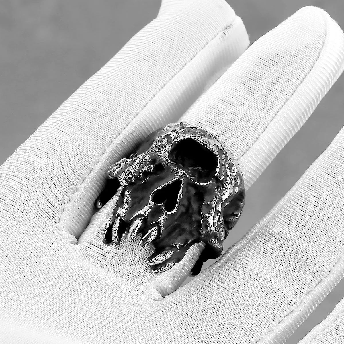 Silver tone alloy ring featuring a detailed one-eyed skull design on a black background.