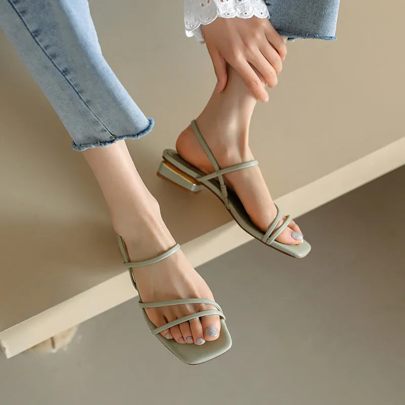 Women's flat beige Roman sandals with multiple straps and a square open toe.