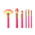 Pink cosmetic makeup brush set with wooden handles and synthetic nylon bristles on a flat surface