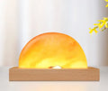 Sunrise Oriental wooden base table lamp with natural crystal salt shade and wireless phone charging pad.