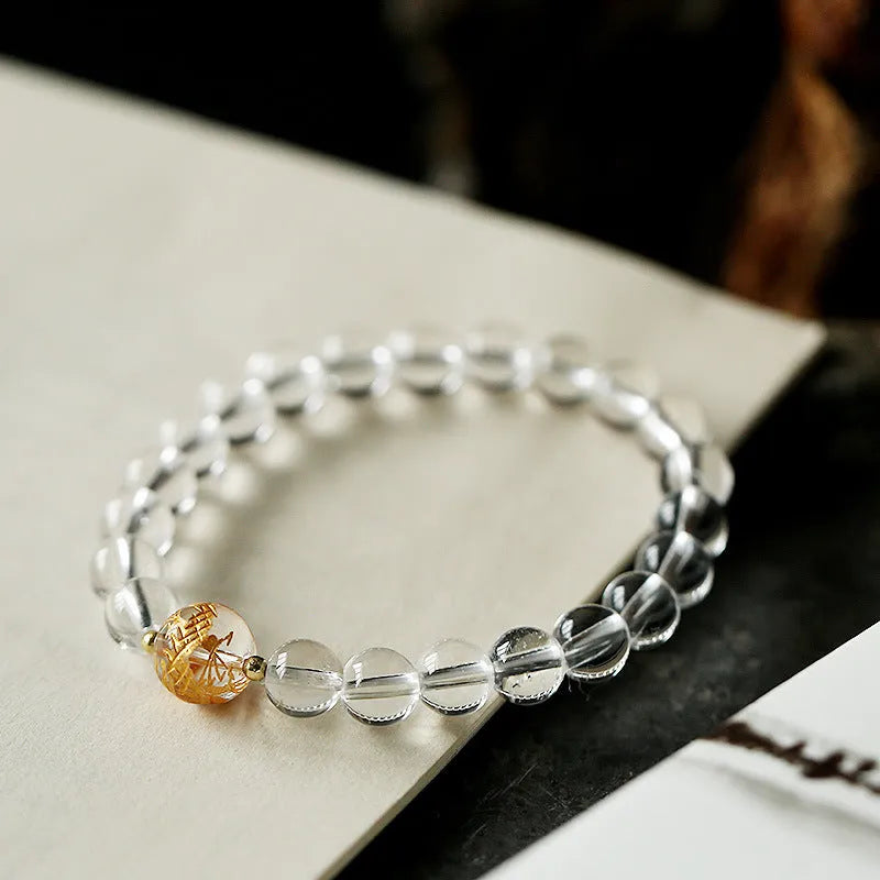 Geometric obsidian white crystal bracelet with black agate beads and golden dragon charm on wrist
