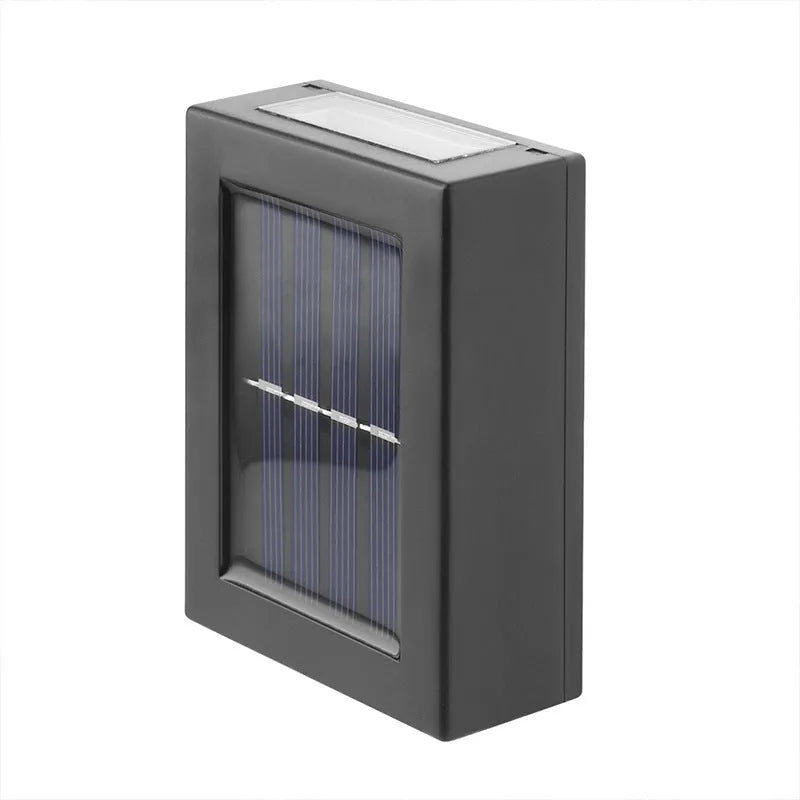 Small black solar-powered outdoor wall light mounted on a garden fence