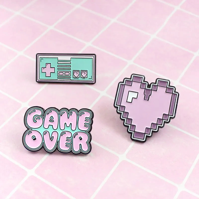 A three-dimensional die-cast alloy metal badge shaped like a stereo game console.