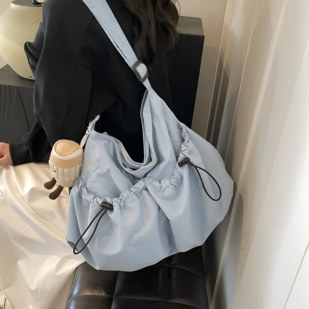 Ultra-light green pleated polyester crossbody bag showing split outer pocket and foldable design.