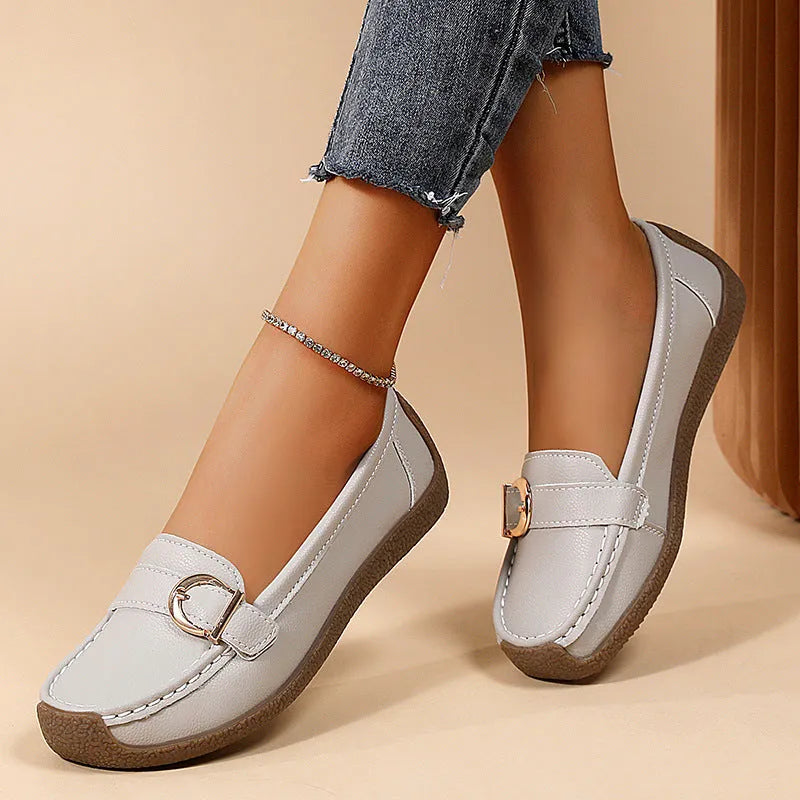 Women's beige casual loafers with round toe and flat heel on a light background.