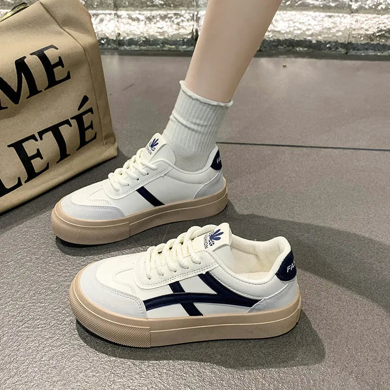 Blue low-top women's casual trainers with round toe and white rubber sole on a plain background.