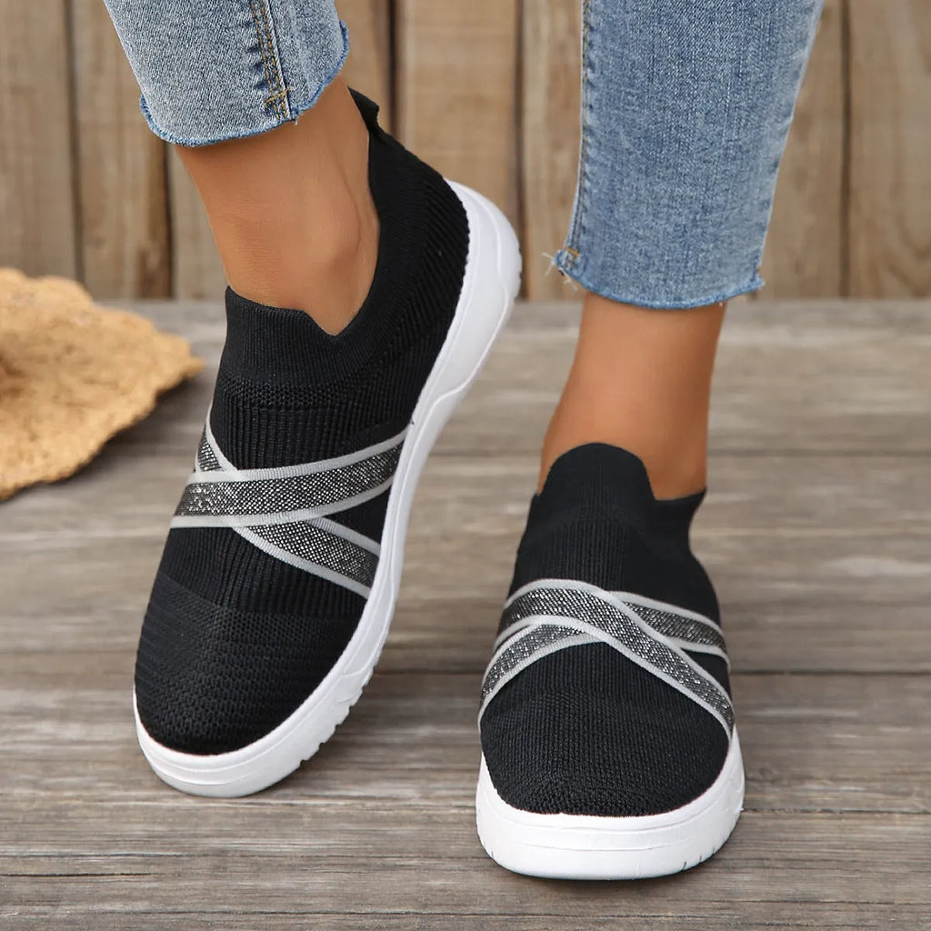 Black women's flat shoes with flyknit mesh upper, round toe, and tassel detail