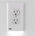 White plug-in socket induction LED night light installed on a wall outlet.