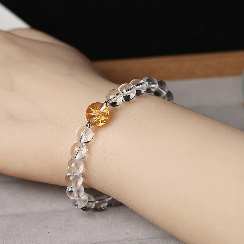 Geometric obsidian white crystal bracelet with black agate beads and golden dragon charm on wrist