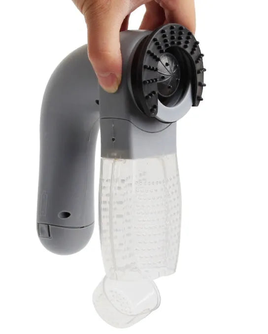 Grey portable pet hair vacuum cleaner with soft rubber grooming head on a fabric sofa