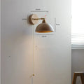 Nordic style wood finish wall lamp mounted beside a bed.