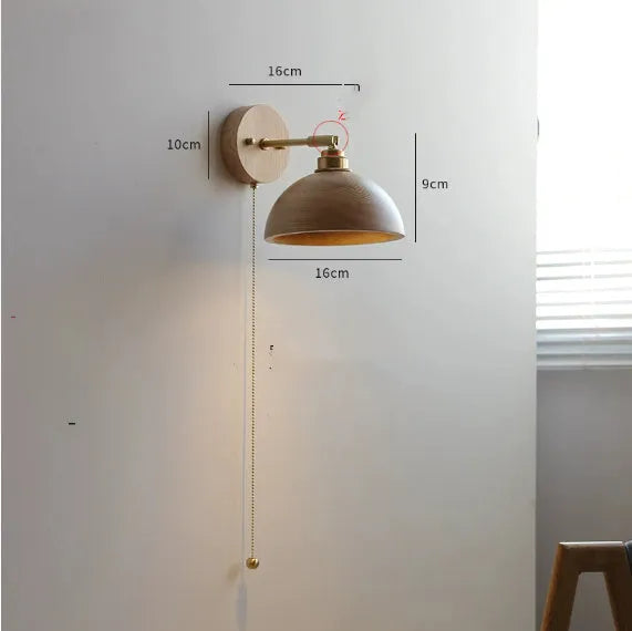 Nordic style wood finish wall lamp mounted beside a bed.