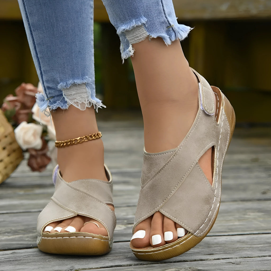 Women's brown Roman sandals with a platform sole, skirt trim detail, and Velcro strap fastening.